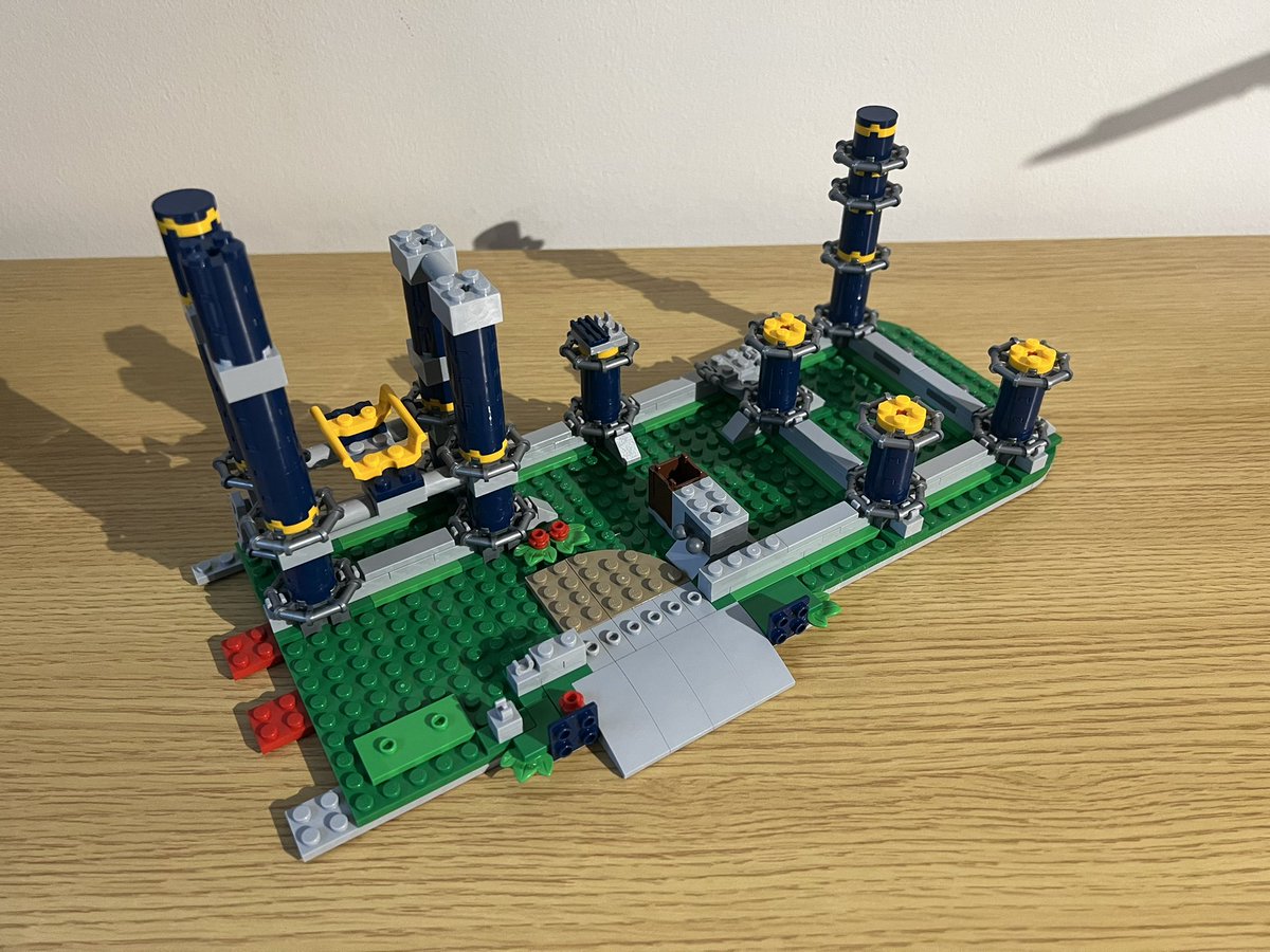 A partially build lego roller coaster. There are nine support poles and a tiny piece of track supported by four of them.