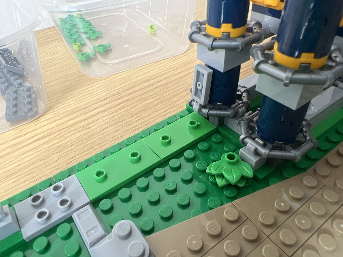 A closeup of a lego roller coaster support pillar. There’s a grey piece clipped to the pillar that doesn’t attach to anything.