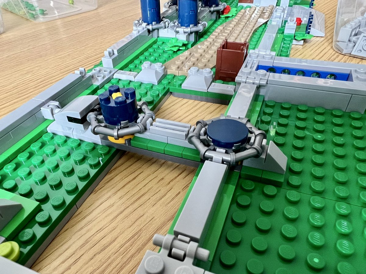 A closeup of two lego roller coaster supports. One is a single brick high, and the other is only as tall as a single tile.