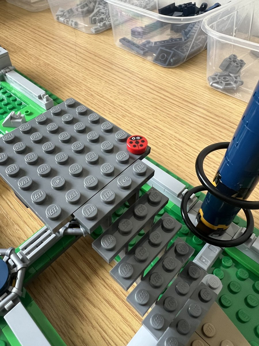 A closeup of the top of a lego staircase where a ladybird is sitting