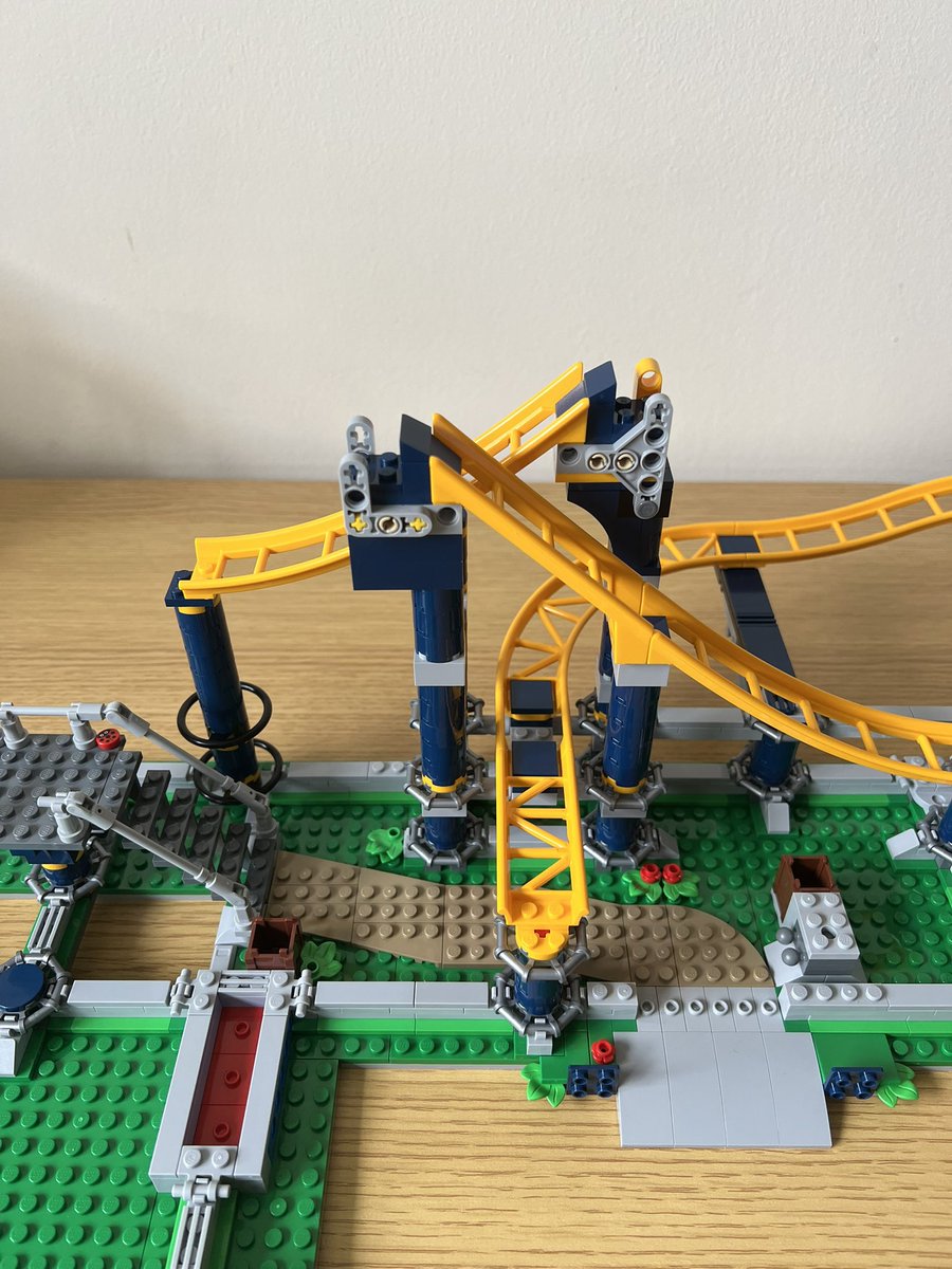 A partially built lego roller coaster. There are two slopes of yellow track side by side which aren’t connected to anything