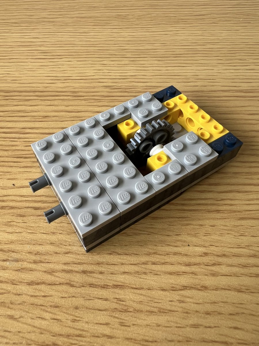 A small lego structure that’s rectangular with a cutout where a gear is mounted.