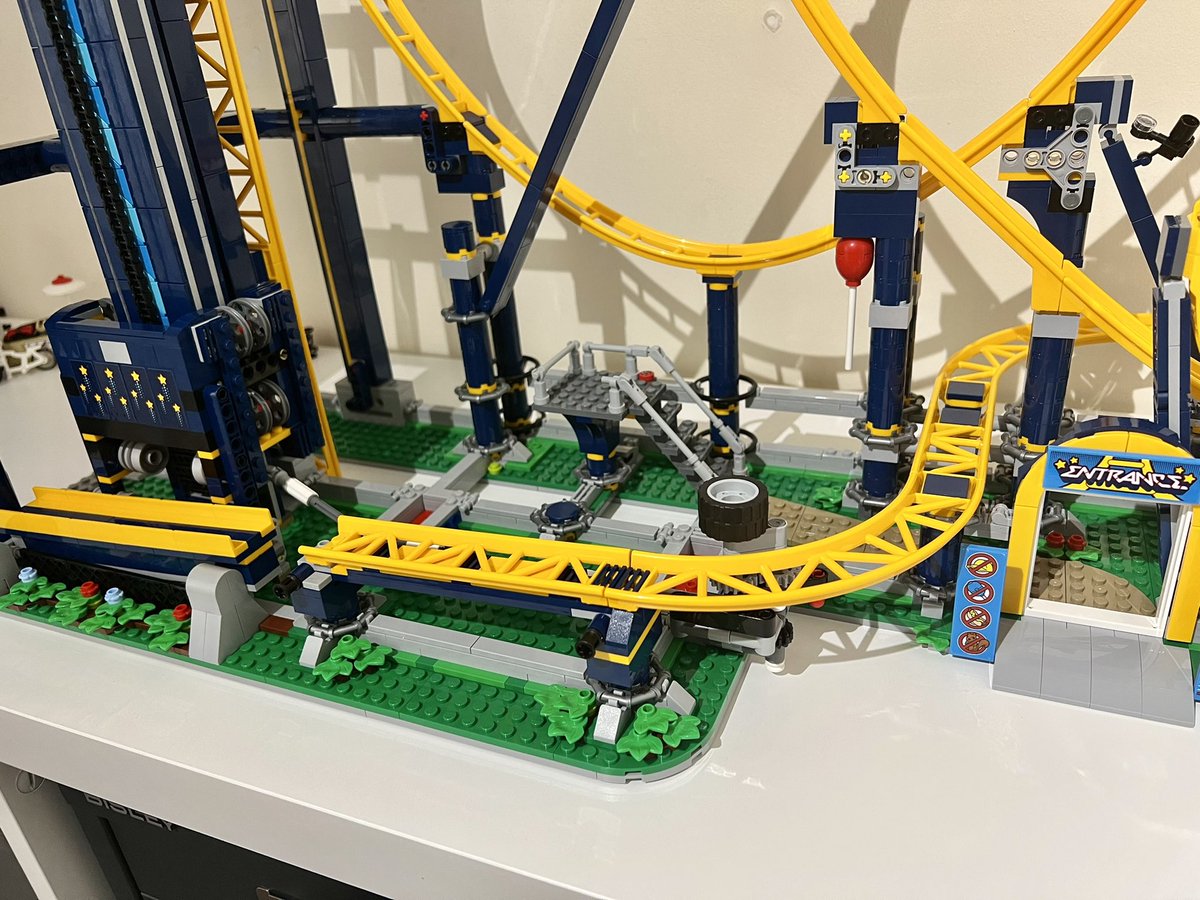 The track of a lego roller coaster showing the final curve before reaching the chain lift again. There’s a tiny gap between the end of the track and the lift.