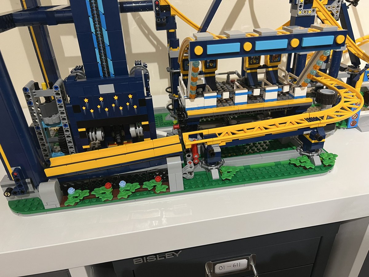 A lego roller coaster focusing on the station and chain lift, showing the final piece has been placed to form a full circuit.