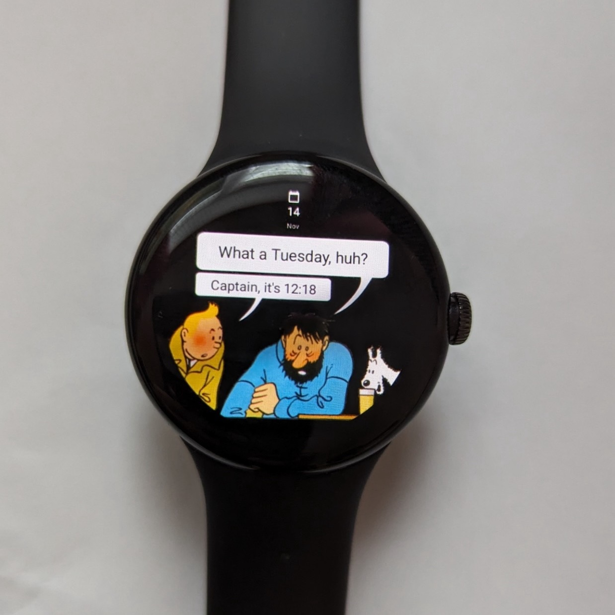 A Pixel Watch running the watch face from this post. Captain Haddock is saying "What a Tuesday, huh?" and Tintin is replying "Captain, it's 12:18"